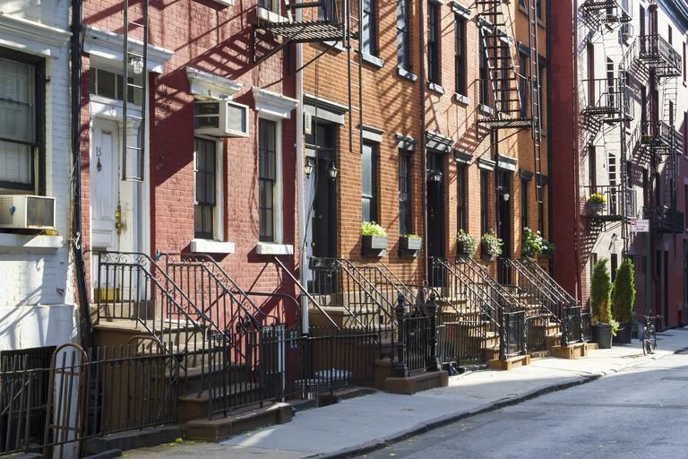 Sunlight shines on a block of historic apartment buildings on Gay Street in the Greenwich Village neighborhood of Manhattan, New York City.